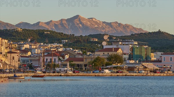 Evening sun illuminates a picturesque harbour town by the sea with mountains in the background, Taygetos Mountains, Taygetos, Gythio, Mani, Peloponnese, Greece, Europe