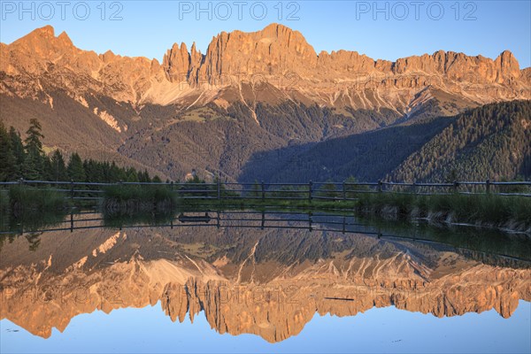 Mountains reflected in a small mountain lake, sunset, evening light, Wuhnleger, view of rose garden, Dolomites, South Tyrol, Italy, Europe