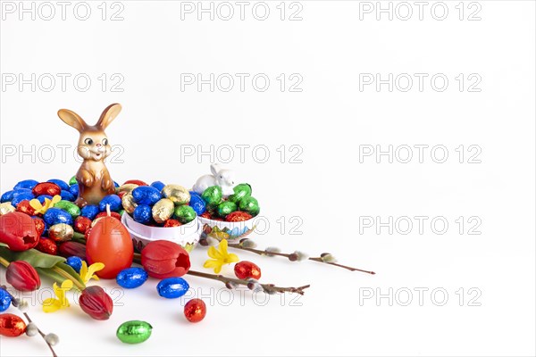Colourful arrangement with chocolate Easter eggs, palm kittens and a cheerful Easter bunny