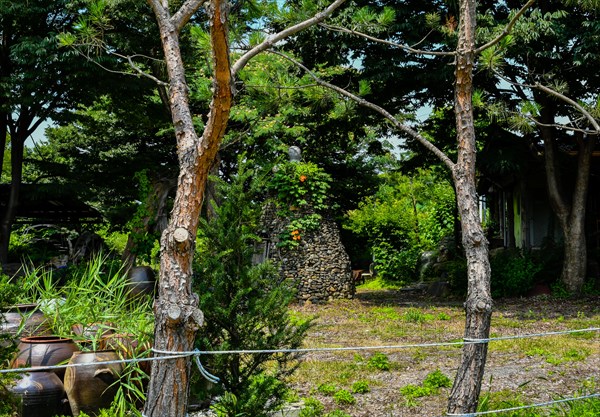 Small stone cone shaped structure with wooden door in beautiful garden in South Korea