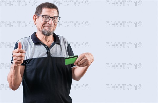 Senior man with credit card making money gesture with fingers, isolated. Senior people holding credit card making money gesture, smiling at camera