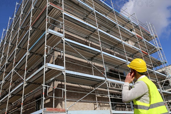 Symbolic image: Architect in front of an apartment block under construction