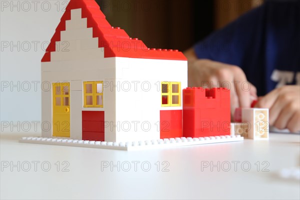 Symbolic image: Boy builds a house with building blocks