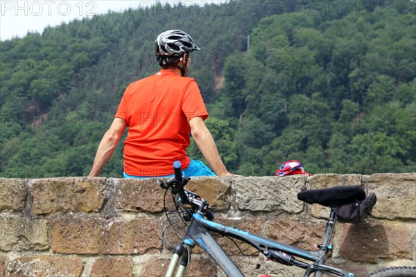 Mountain biker takes a break at the Wolfsburg above Neustadt an der Weinstrasse