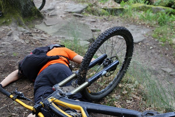 Injured mountain biker lying on the ground in an accident