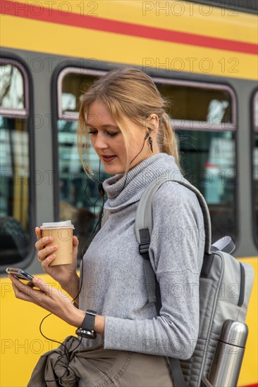 Close-up of a young woman in front of a train at the station