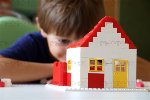 Boy builds a house with building blocks