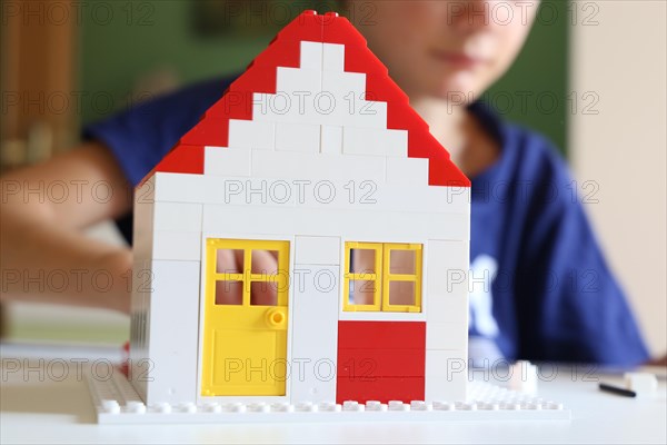 Symbolic image: Boy builds a house with building blocks