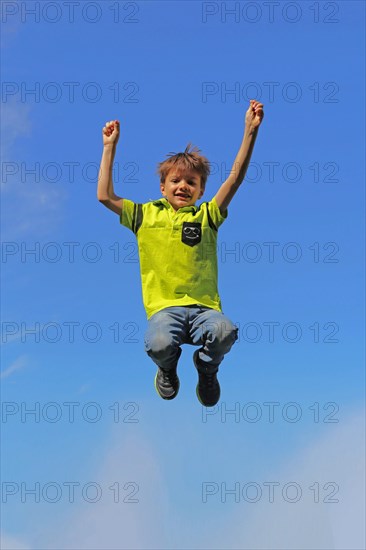 Symbolic image: Boy jumping into the air, blue sky in the background