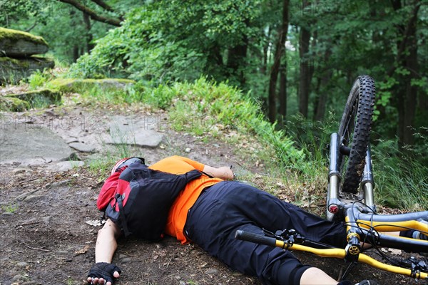 Injured mountain biker lying on the ground in an accident