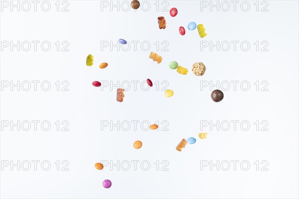 Colourful sweets fall against a white background