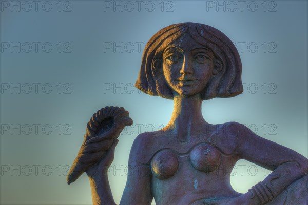 Detailed sculpture of a woman in front of a sunrise sky, mermaid, Gythio, Mani, Peloponnese, Greece, Europe