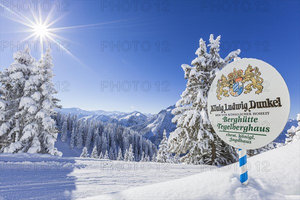 Ski slope in front of mountain landscape, Tegelberghaus sign, winter, sun star, Tegelberg, Ammergau Alps, Upper Bavaria, Bavaria, Germany, Europe