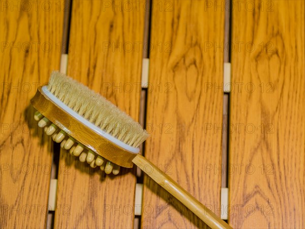 Bath and massage brush on wood grain background. Personal tool for massage spa and sauna accessory