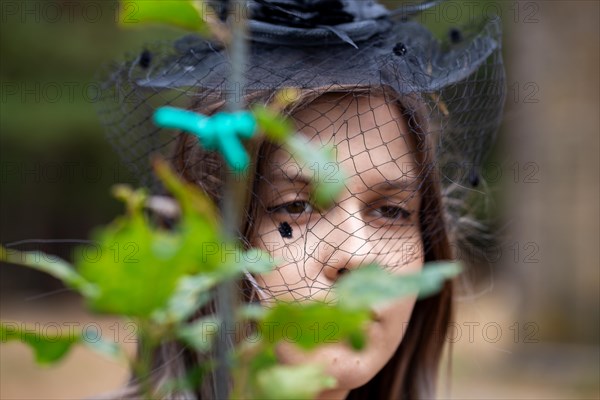 Close-up of a grieving young woman with a mourning veil (symbolic image)