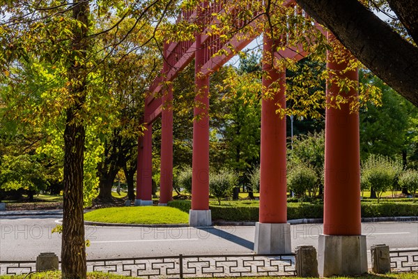 Closeup of columns of large Japanese style wooden gate across four lane road in public park in South Korea