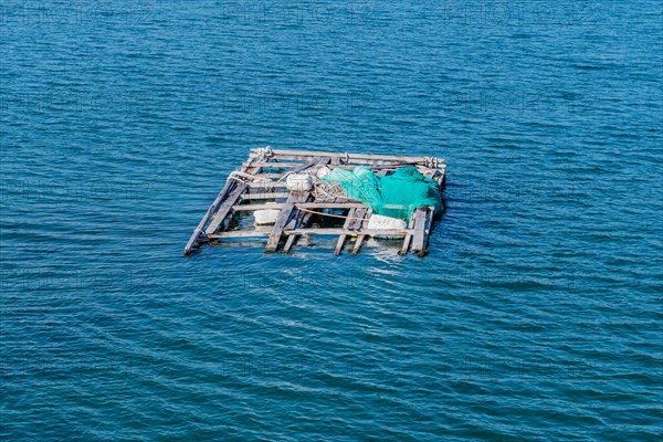 Dilapidated wooden raft held afloat with Styrofoam floats in ocean seaport in Yeosu, South Korea, Asia