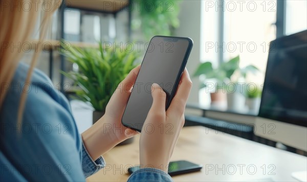 Cropped image of young businesswoman using smartphone while sitting at desk in office. Mockup AI generated