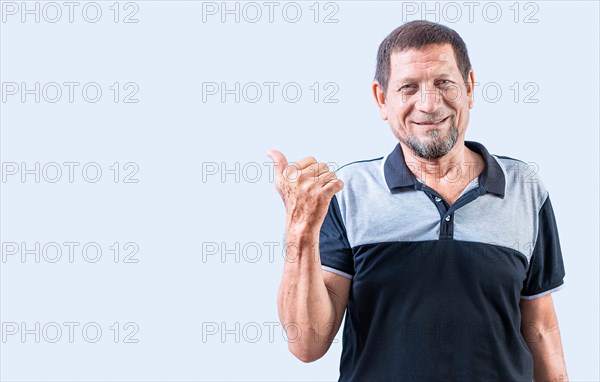 Smiling senior man pointing at a banner to the side. Senior old man pointing at promotion isolated