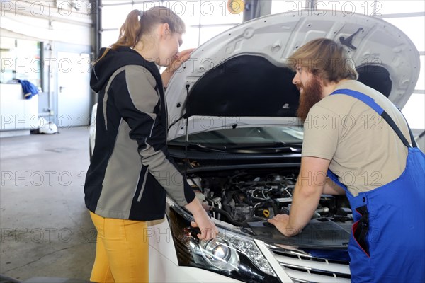 Symbolic image: Car mechatronics technician with customer in the garage