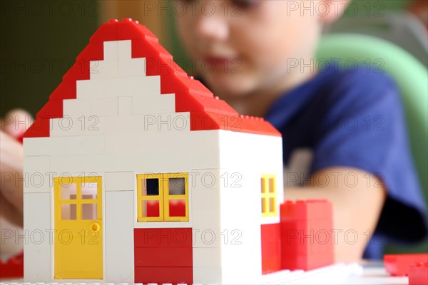 Boy builds a house with building blocks