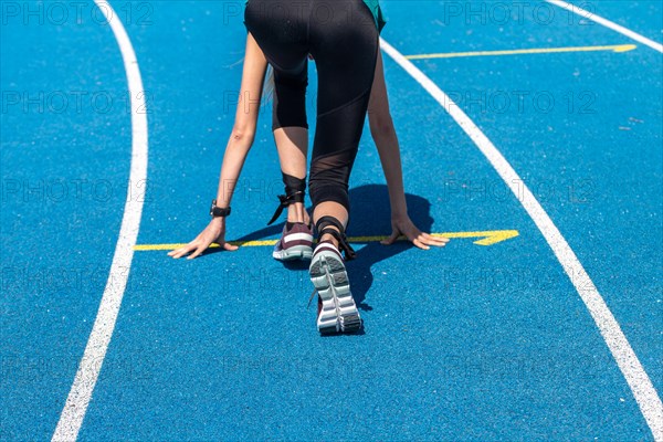 Athletics symbol: Young woman in front of the start of a race
