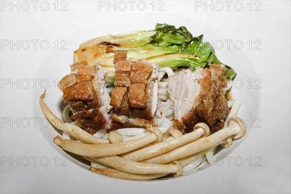 Crispy fried pork belly on Japanese udon noodles, with briefly braised pak choi and enoki mushrooms, food photography