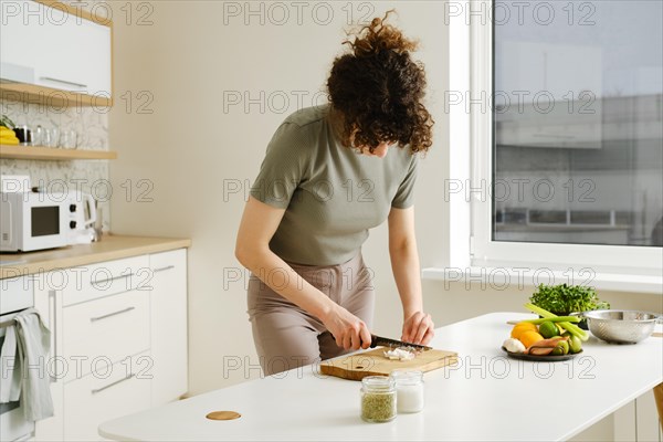 Young woman cutting shallot onion in the kitchen