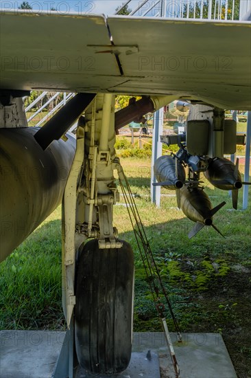 Rear view of landing gear and battery of missiles mounted under wing of military jet aircraft on display in public park