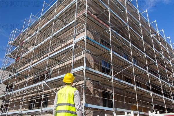 Symbolic image: Architect in front of an apartment block under construction