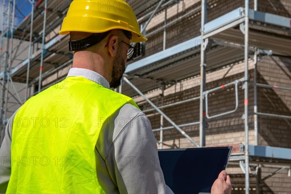 Symbolic image: Architect in front of an apartment block under construction