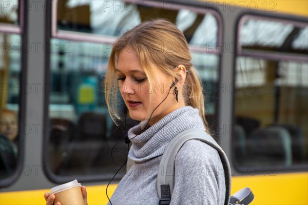 Close-up of a young woman in front of a train at the station