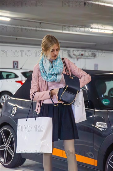 Elegant young woman in a car park