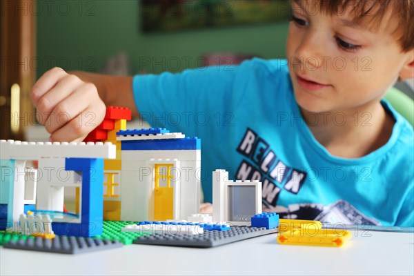 Boy builds a house with building blocks