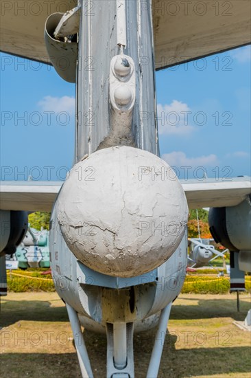 Rear view of ventrally-mounted retractable radar boom on military airplane in public park