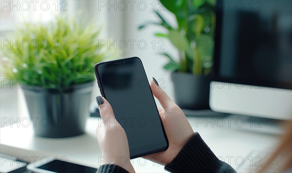 Woman using smartphone with blank screen at workplace in office. Mock up AI generated
