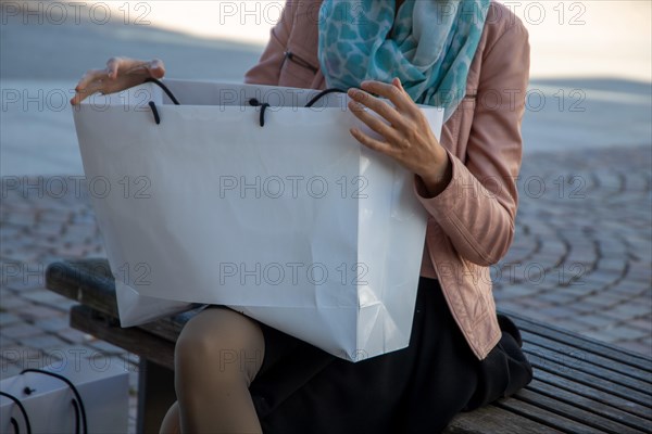 Young woman with white carrier bags shopping in the city