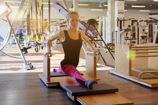 Young woman training on equipment in the gym