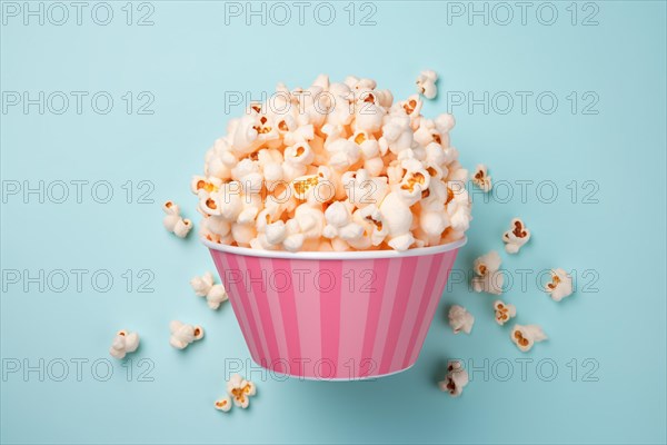 Pink striped bowl with popcorn on blue background. KI generiert, generiert AI generated