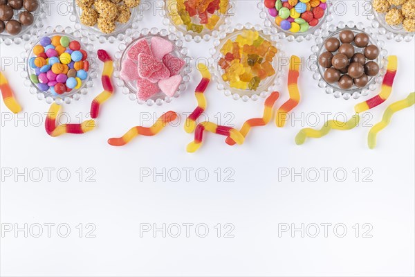 Sweets on and next to small glass plates on a white background, copy room