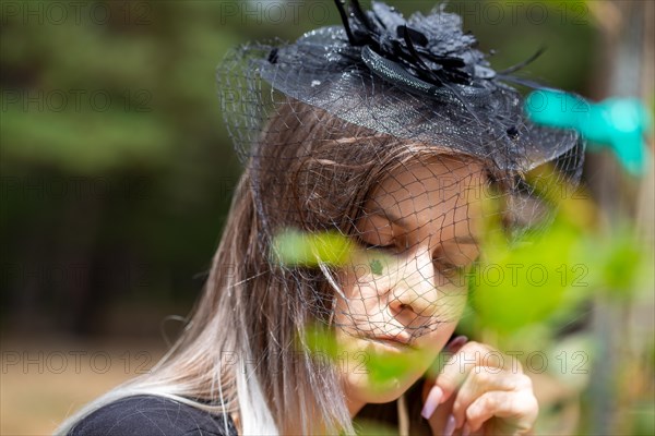 Close-up of a grieving young woman with a mourning veil (symbolic image)