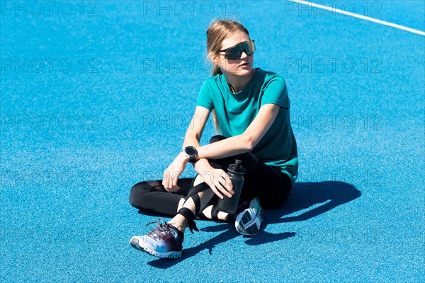 Young track and field athlete on a blue tartan track (symbolic image)