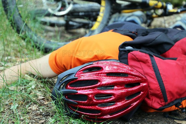 Injured mountain biker lying on the ground in an accident