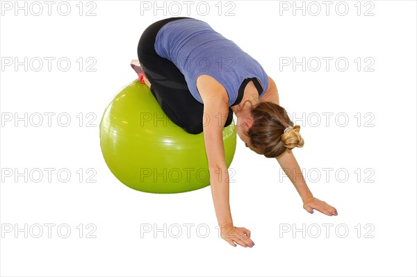 Symbolic image: Young woman doing exercises on an exercise ball against a white background