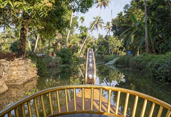 View from the bow of a cruise boat offers a perspective of a canal near Kumarakom, Kerala backwaters, India, Asia