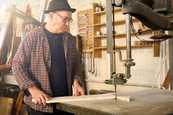 Furniture restorer works with a jigsaw