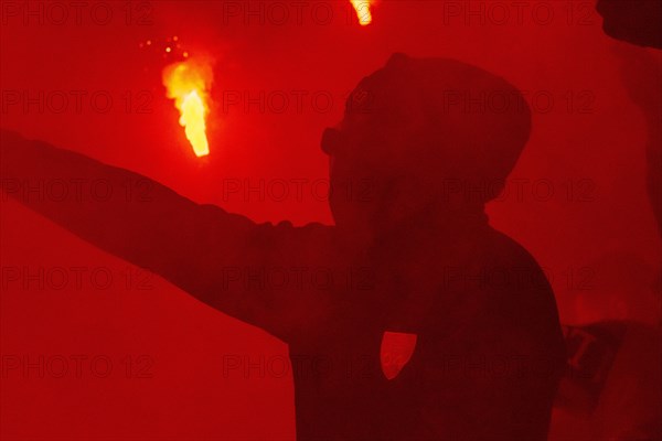 BayArena Leverkusen, 6.2.2024, Football: DFB Pokal 2023/24 quarter-final, Bayer 04 Leverkusen (B04) vs VfB Stuttgart (VFB) - masked Bayer 04 fan in the beacon of Bengalos (DFL DFB REGULATIONS PROHIBIT ANY USE OF PHOTOGRAPHS AS IMAGE SEQUENCES AND/OR QUASI-VIDEO)