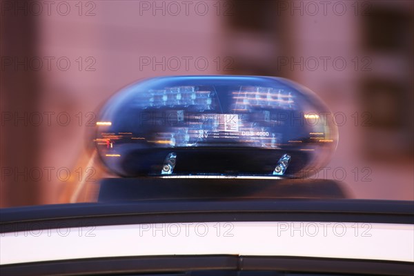 Symbolic image of a police operation: close-up of a flashing blue light on a police car