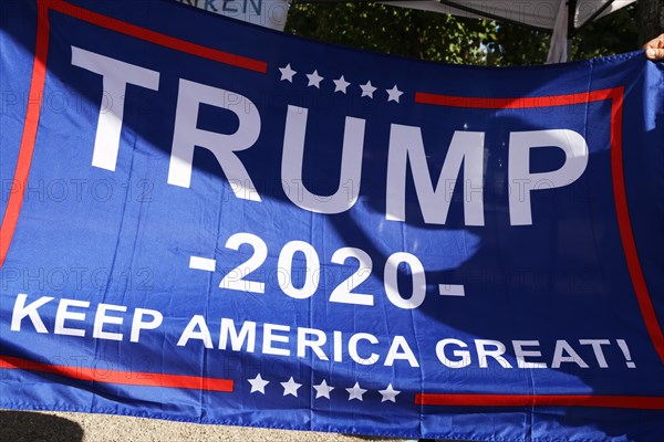 Convinced Trump supporters in Germany hold up a banner with the campaign slogan Trump 2020 - keep America great