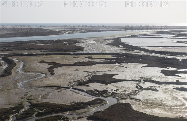 Coastal landscape of salt marsh and drainage channels along the coastline off Faro, Algarve, Portugal, Europe